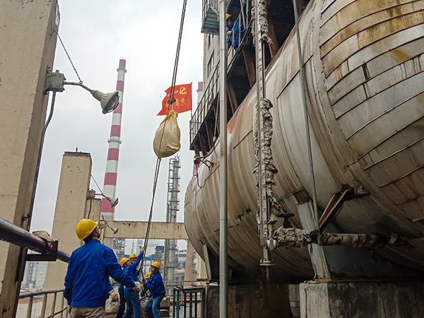 5月10日中午，在動(dòng)力車(chē)間三期工藝除氧器地面，黨員突擊隊(duì)隊(duì)員用滑輪往工藝除氧器平臺(tái)運(yùn)送鋼絲網(wǎng)，用以纏繞新填料.jpg