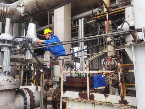 氣化爐上，柳曦、徐騰飛冒雨調(diào)試氣化爐電動(dòng)閥.jpg