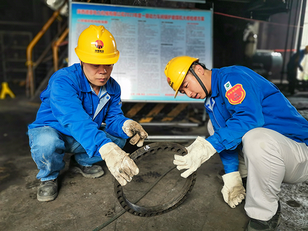 圖三：12日下午14時，在一期磨煤機廠房，陜西省技術(shù)能手姬霄給青工張跟潮講解磨煤機搖臂曲拐內(nèi)環(huán)及動作原理。.jpg